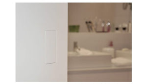 Modern minimalist white spring-loaded flush pull handle installed on a sliding bathroom door.