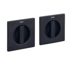 Two black square wall plates with circular cutouts on a white background