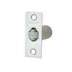 A silver metal door stopper adjustment bracket with a cylindrical rod extending to the right, featuring an 'ADJUST' dial on the front plate, shown against a plain white background.