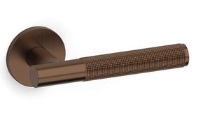 Bronze door handle with textured grip on a white background